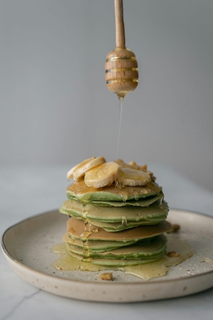 Fluffy banana pancakes with matcha drizzled with honey