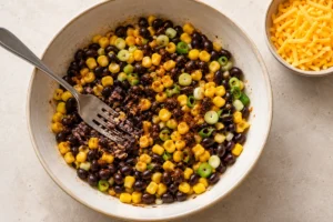 Black beans and corn mixed with spring onion and spices, with a few beans mashed