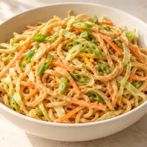 Peanut noodles with cabbage, carrot and spring onions in creamy peanut sauce
